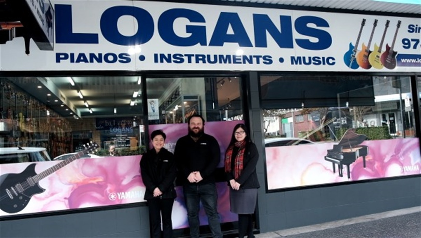 image of business owner and employees standing at shop front