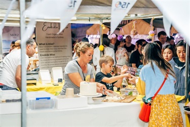 woman cutting cake at a market stall