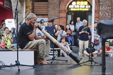 man playing didgeridoo on stage