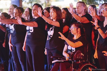 choir singing with hands held up
