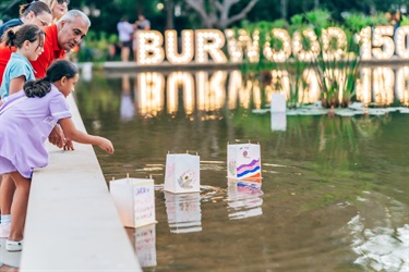 girl floating lanterns on pond