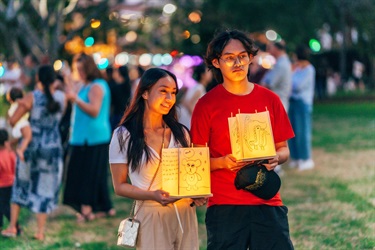 man and woman each holding a lantern