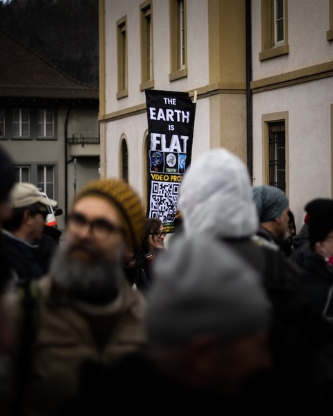 Fake news phot showing man with a flat world poster
