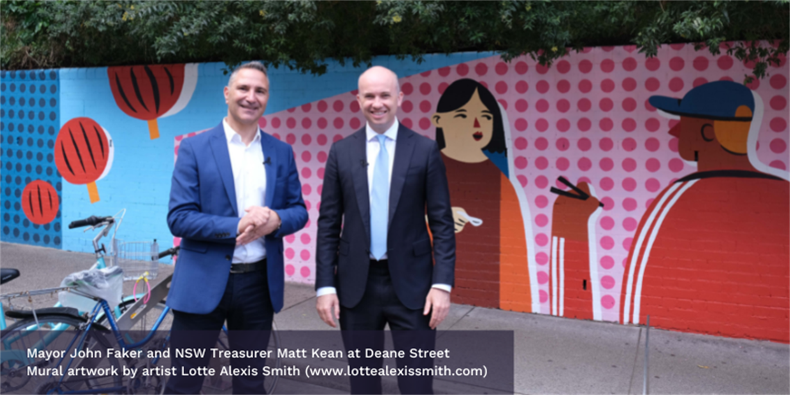 Mayor John Faker and NSW Treasure Matt Kean standing smiling in front of a colourful wall mural