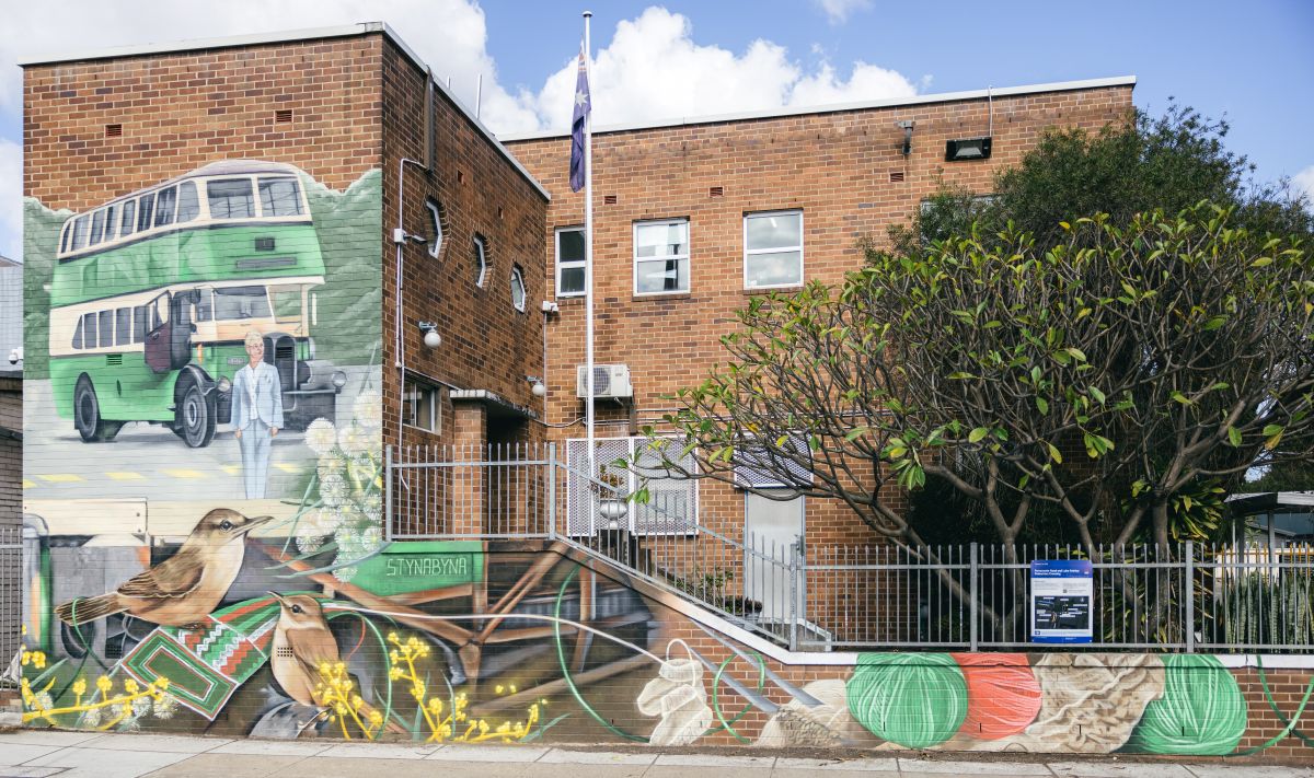 Mural at Burwood Bus Depot showing a double-decker bus, birds, and yarn patterns celebrating Lorna Hutchings and community