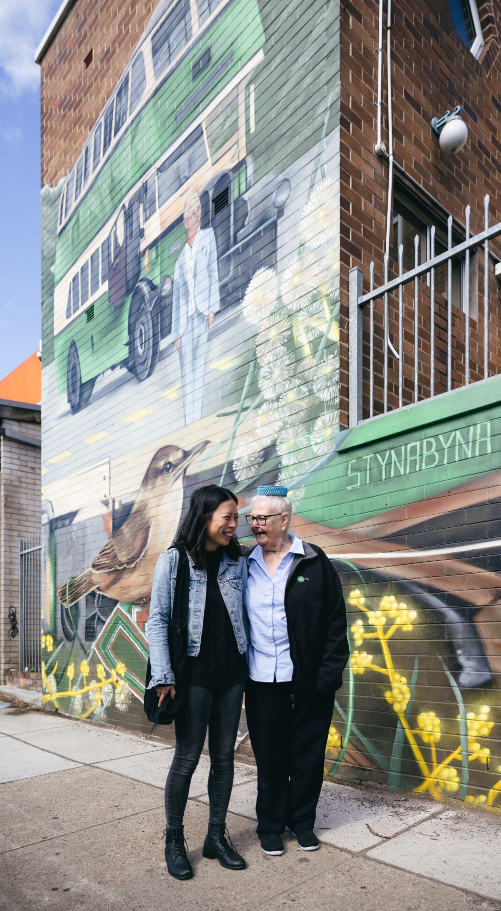 close up photo of mural at Burwood Bus Depot showing a double-decker bus, birds, and yarn patterns celebrating Lorna Hutchings and community
