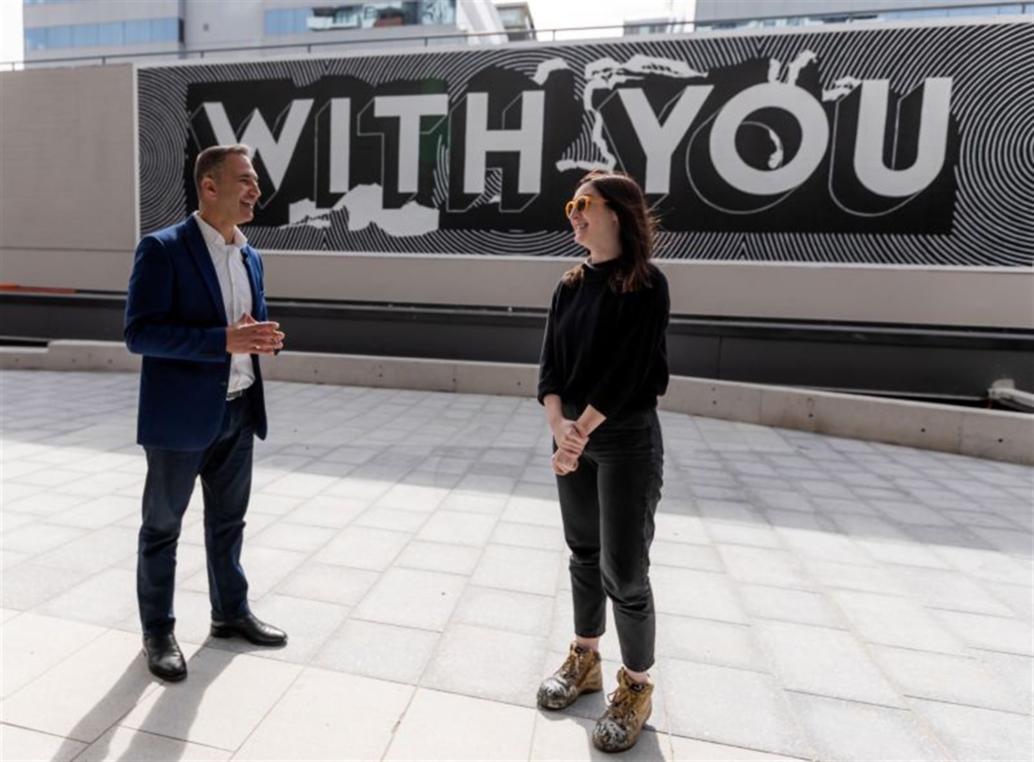 the mayor chatting to artist Georgia Hill in front of the with you black and white wall mural